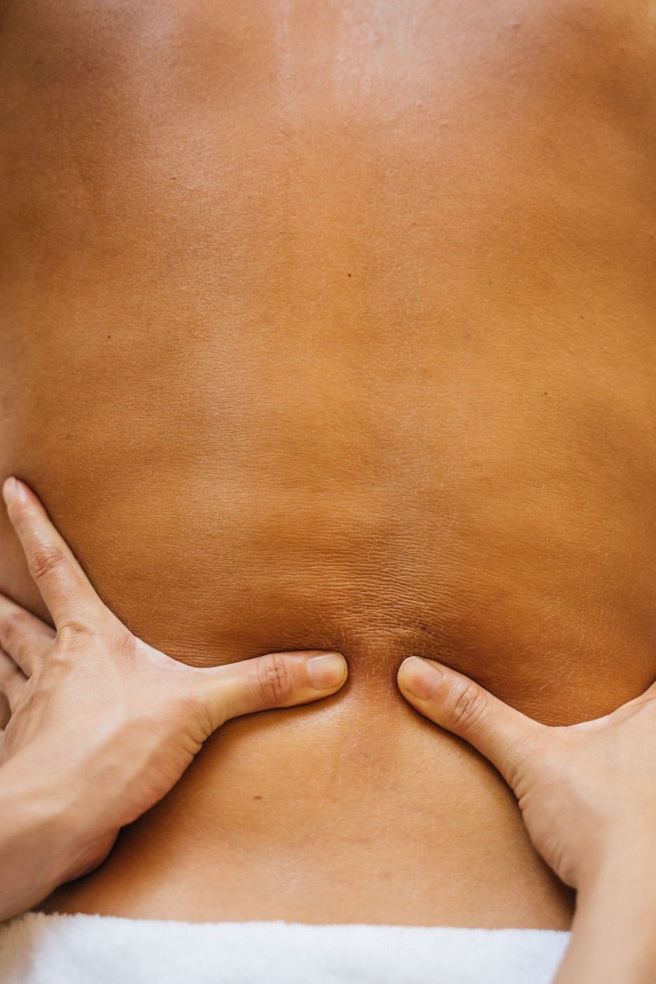 Mains d'une praticienne pendant un massage du dos